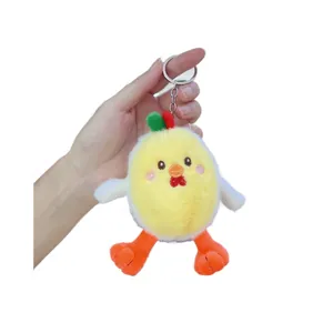 Porte-clés poussin en peluche jaune avec joues roses tenu à la main sur fond blanc