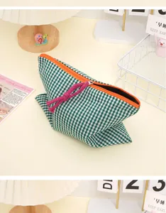 Detail of green gingham cosmetic bag with orange zipper and purple cord pull