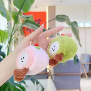 Close-up of pink and green plush cake pendants with smiling faces and metal chains