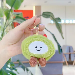 Close-up of green matcha plush strawberry cake pendant with a smiling face and metal chain
