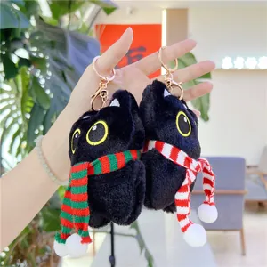 Close-up of black cat plush keychain with colorful scarves and rose gold metal clasp