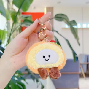Close-up of fluffy orange plush cake charm with a cute smile and golden keychain