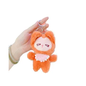 Cute orange fox plush keychain with pink bib and closed eyes on white background