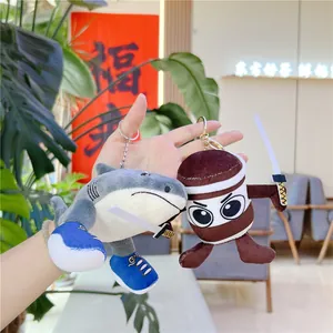 Close-up of plush shark and ninja doll keychains with swords held in hand