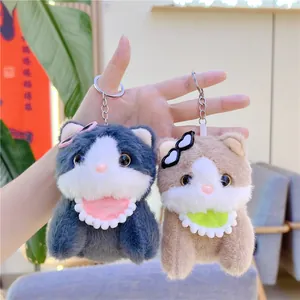 Detail of plush cat keychains with glasses and lace bibs in gray and brown fur