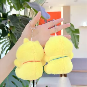 Pair of yellow plush cat keychains with soft fur and colorful neck cords held by hand