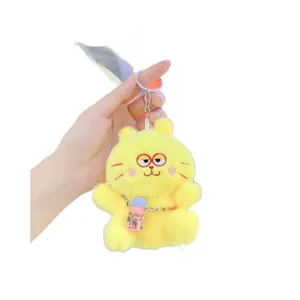 Plush yellow cat keychain with red glasses and pink GO PLAY bottle in hand