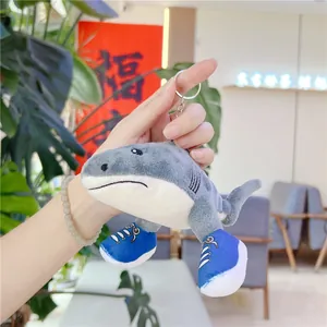Detail of shark plush keychain featuring cute blue canvas shoes and soft grey texture