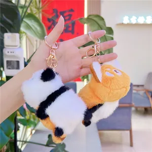 Detail von Panda- und orangefarbenen Plüsch-Schlüsselanhängern mit Gold-Karabiner