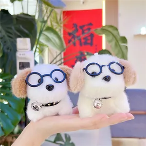 Cute plush puppy keychains with glasses and silver bells, held in hand to show size