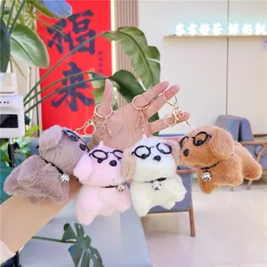 Cute plush puppy keychains with glasses and bells in multiple colors held in hand