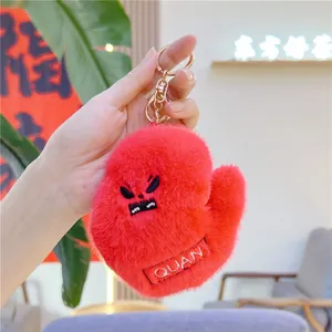 Plush cartoon sports keychain with expressive red hand design and golden metal ring