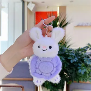 Detalle de llavero de conejo de peluche blanco con caparazón de tortuga púrpura y aro