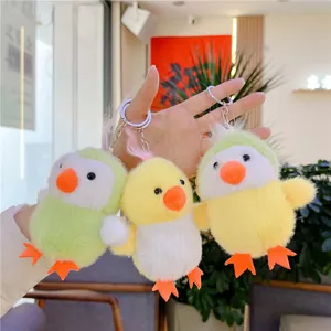 Three plush chick keychains in pastel yellow and green held in a hand for bag decor