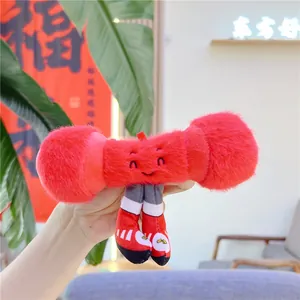 Detail of a red plush dumbbell-shaped keychain with an embroidered face and tiny sneakers