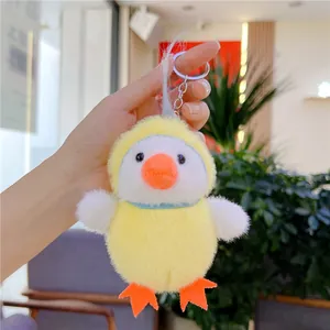 Close-up of a soft yellow plush chick keychain with metallic ring held in hand