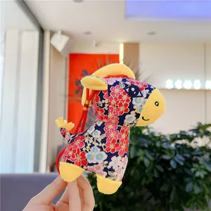 Detail of floral fabric zodiac horse plush with red plum patterns and yellow accents