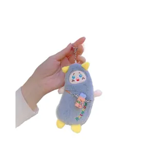 Schattige grijze monster banaan pluche sleutelhanger met roze flesje en regenboog borduursel