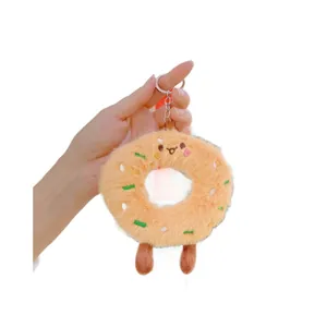 Cute plush donut keychain with embroidered face and colorful sprinkles on white background