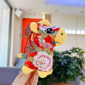 Detail of red floral silk fabric and soft yellow plush on a Chinese zodiac mascot