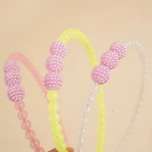 Three beaded headbands in pink, yellow, and white with textured faux pearl accents