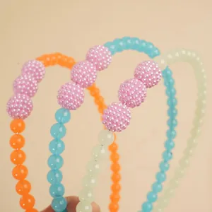 Handmade beaded headbands in blue, orange, and mint green with textured pink beads