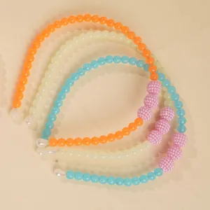 Detailed set of three beaded headbands in orange, cream, and sky blue with pink accents