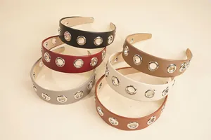 Flat lay of wide PU leather headbands with metal eyelets in six assorted colors