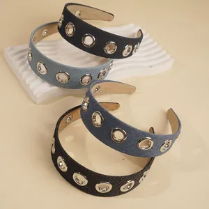 Detail showing denim headbands with silver metal grommets on a neutral background