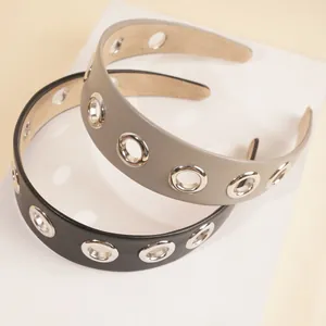 Detailed macro shot of PU leather headbands with silver metal eyelet grommets and texture