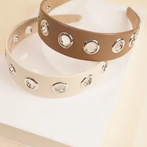 Close-up of PU leather headbands with hollow metal eyelets in brown and beige