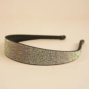 Nahaufnahme glitzernder bunter Strasssteine auf einem breiten schwarzen Haarband mit Pavé-Design