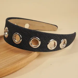 Detailed texture of blue denim headband with five silver metal eyelet grommets