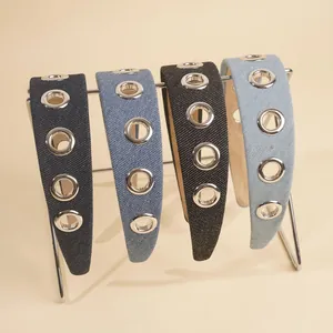 Denim wide headband with silver metal eyelets in four shades on a display stand