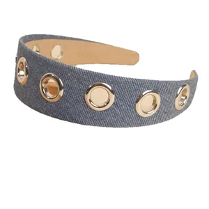 Wide denim headband with gold grommets and non-slip lining on a white background