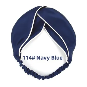 Detail view of navy blue twisted headband with white piping and satin silk texture