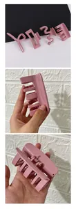 Detail of four pink hair claw clips in various minimalist shapes with metal spring