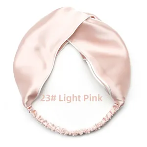Detail of light pink satin cross headband with elastic back and white piped edges