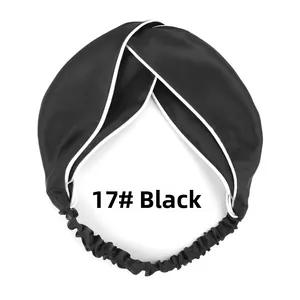 Detail of black satin headband with white piping, twisted knot design, and elastic back