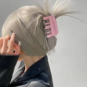 Pink rectangular claw clip securing ash-blonde hair for a stylish minimalist look