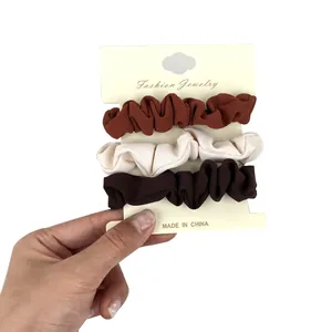 Set di tre elastici per capelli in tessuto marrone, beige e cioccolato su scheda