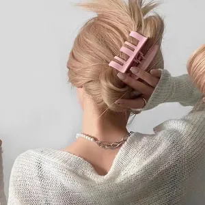 Pink matte shark hair claw clip styled on a low bun for minimalist aesthetic hairstyles