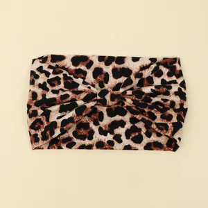 Detail view of a wide leopard print headband with a stylish front knot design