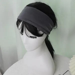 Close-up of wide dark grey elastic sports headband worn by a mannequin for yoga or running