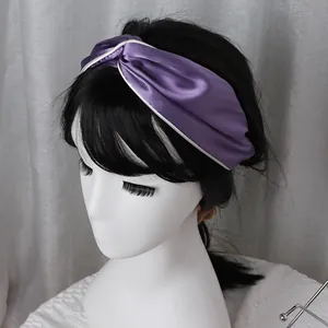Elegant purple silk satin twisted headband with white trim shown on a model head