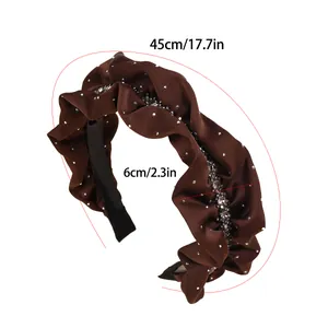Close-up of pleated coffee satin headband with sparkling crystals and size markings