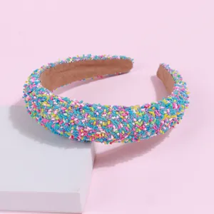 Detailed shot of padded candy color headband with colorful grain texture on a pink background