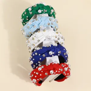 Close-up of knotted fabric headbands featuring baroque pearls and sparkling rhinestones