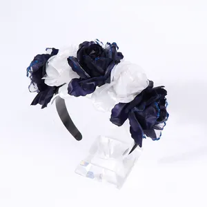 Dettaglio di rose in seta blu e bianche su cerchietto con bordi glitterati