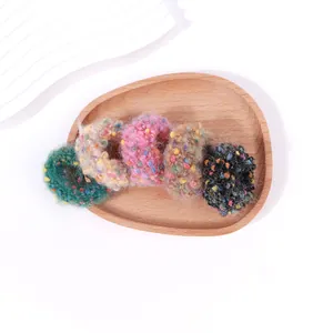 Detalle de set de 5 coleteros de punto de colores en una bandeja de madera